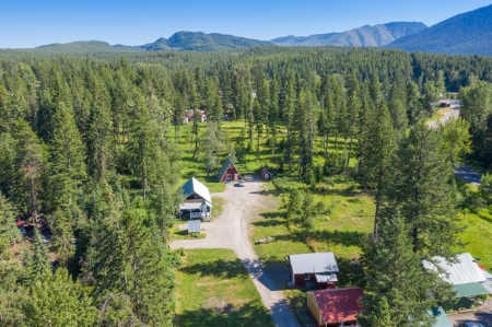 Historic cabins and mountain backdrop at Spotted Bear Retreat in Montana